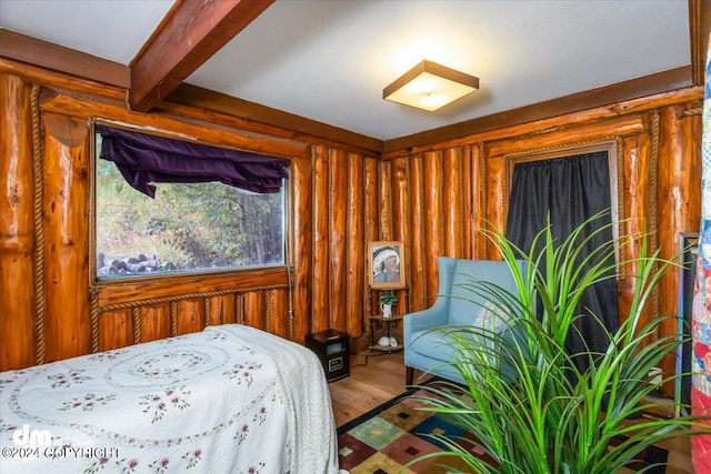 bedroom featuring wood-type flooring and beam ceiling