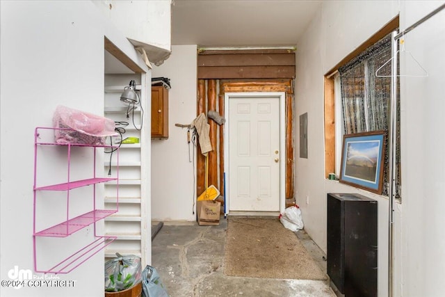 interior space with electric panel and concrete floors