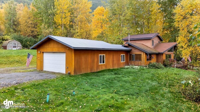 view of front of home with a storage unit, a garage, and a front yard