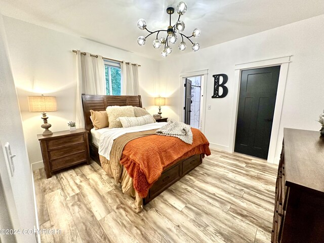 bedroom with light wood-type flooring and an inviting chandelier