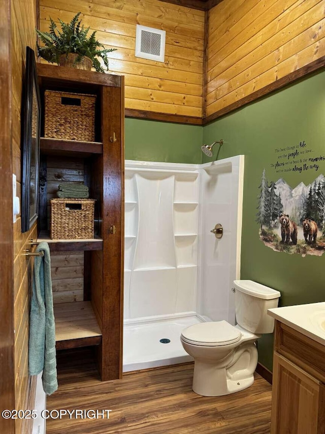 bathroom with toilet, a stall shower, vanity, and visible vents