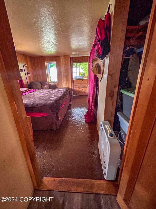 bedroom with a textured ceiling and wooden walls