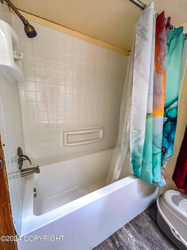 bathroom featuring hardwood / wood-style flooring and shower / bath combination with curtain