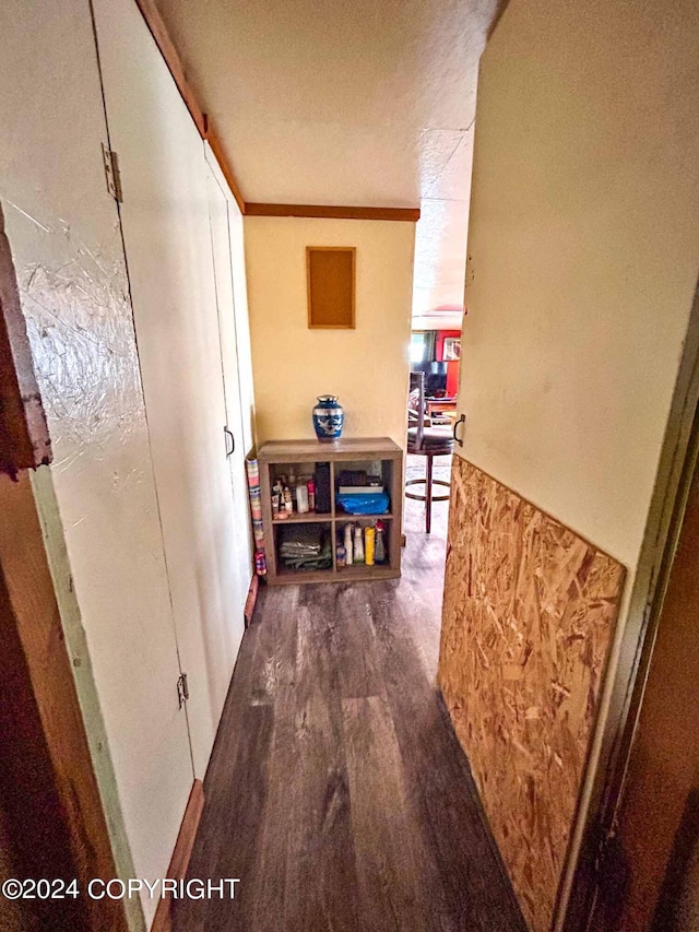 hall with a textured ceiling, crown molding, and dark hardwood / wood-style floors