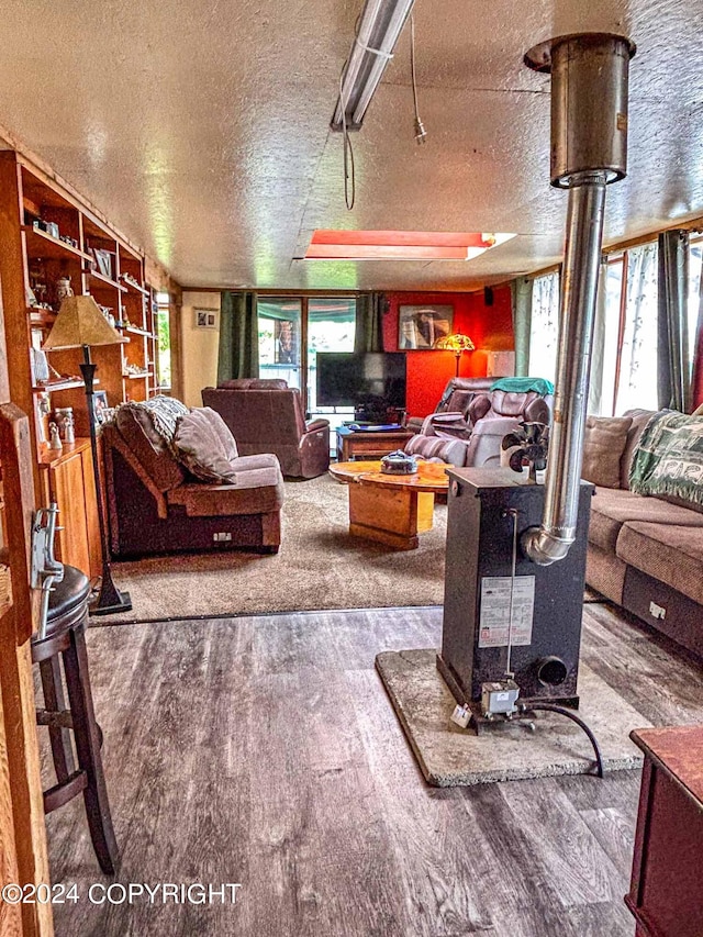 living room featuring a textured ceiling, plenty of natural light, and a wood stove