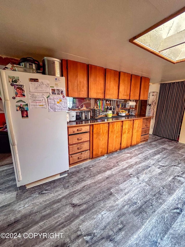 kitchen with a textured ceiling, white fridge, and hardwood / wood-style floors