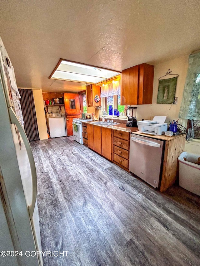 kitchen with washer / dryer, dark wood-type flooring, a textured ceiling, and stainless steel appliances