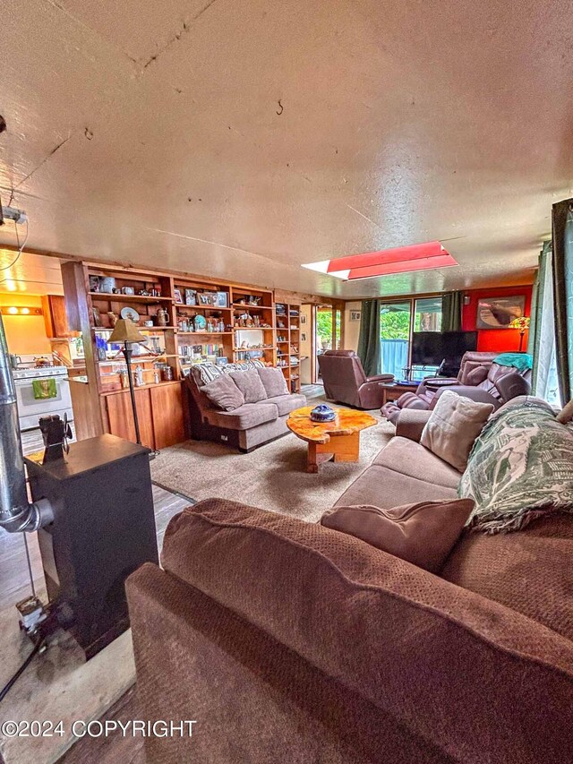 living room with a textured ceiling and a wood stove