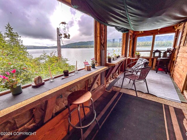 view of patio with an outdoor bar and a water view