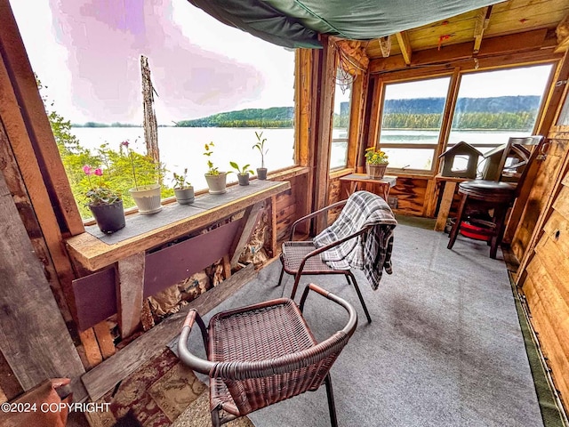 sunroom featuring a water view