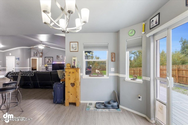 dining room with hardwood / wood-style floors, ceiling fan with notable chandelier, and vaulted ceiling