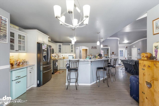 kitchen featuring hanging light fixtures, dark hardwood / wood-style floors, appliances with stainless steel finishes, and white cabinetry