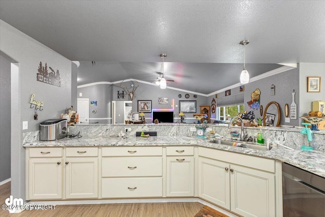 kitchen with dishwasher, light hardwood / wood-style flooring, vaulted ceiling, cream cabinetry, and ceiling fan