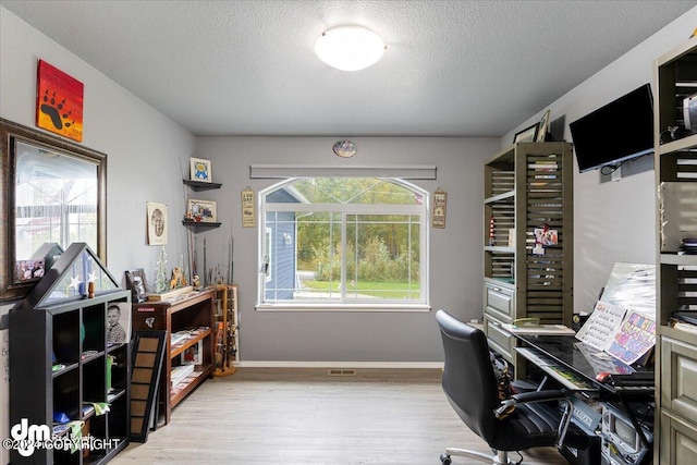 office space with light hardwood / wood-style floors and a textured ceiling