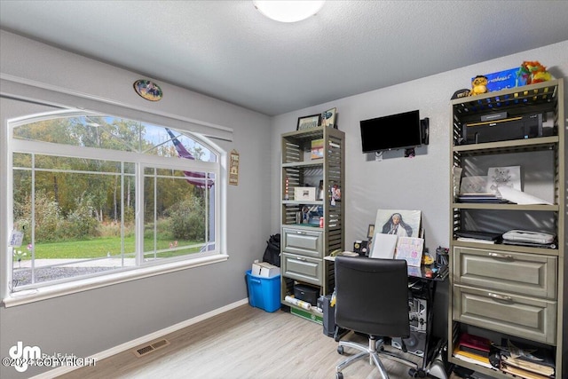 home office featuring hardwood / wood-style flooring and a textured ceiling