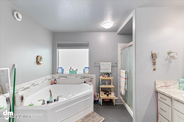 bathroom featuring independent shower and bath, a textured ceiling, and vanity