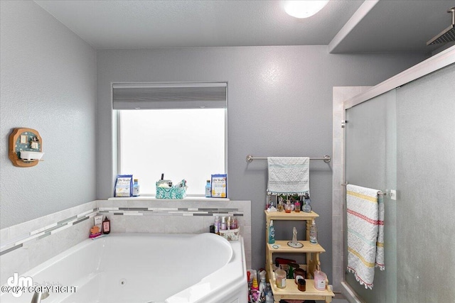 bathroom with separate shower and tub and a textured ceiling