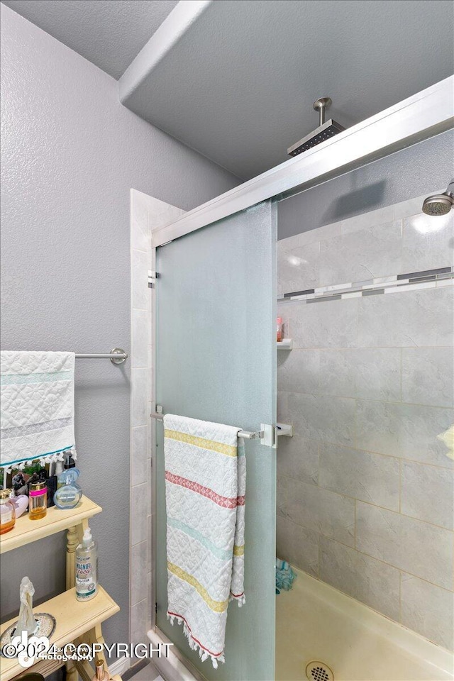 bathroom with a shower with door and a textured ceiling