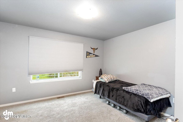 carpeted bedroom featuring a textured ceiling