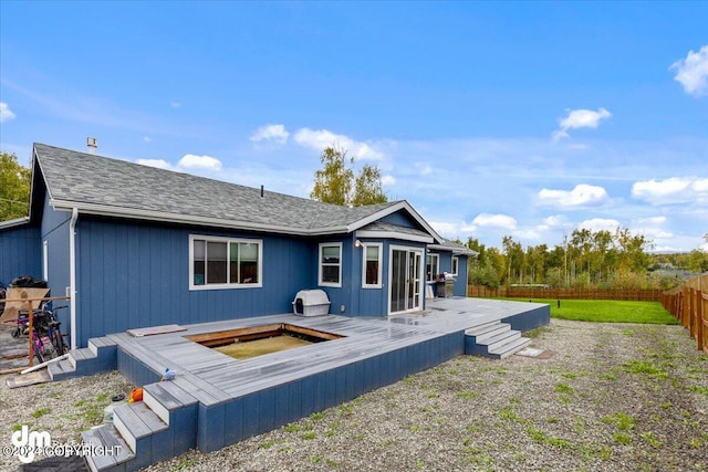 back of house with a wooden deck and a hot tub