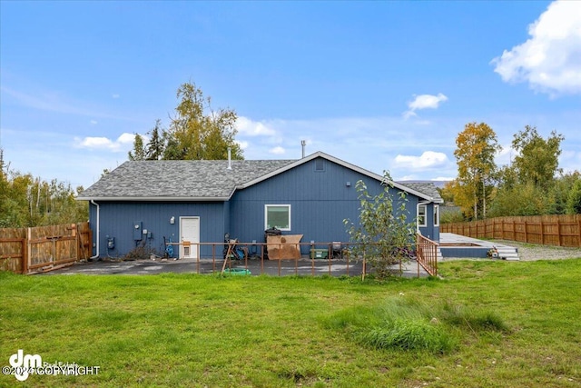 back of house featuring a lawn and a patio