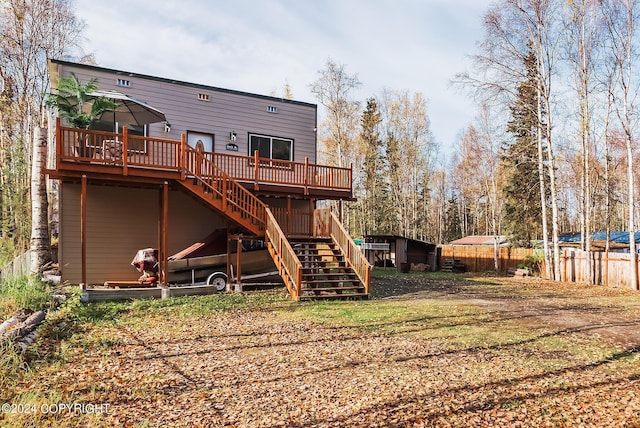 back of property featuring fence, a deck, and stairs