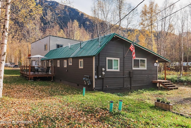 view of side of property featuring metal roof, a deck with mountain view, and crawl space