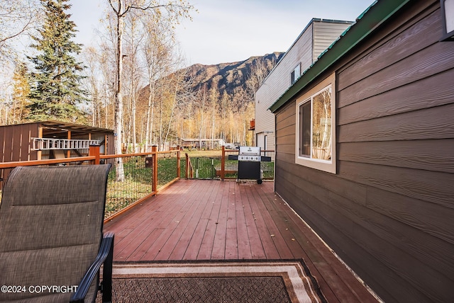 wooden terrace with a grill and a mountain view