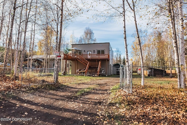 rear view of house with fence, stairway, and a wooden deck