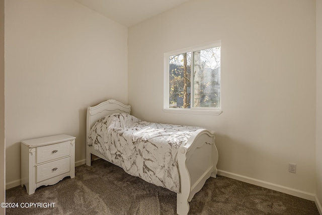 bedroom featuring baseboards and dark carpet