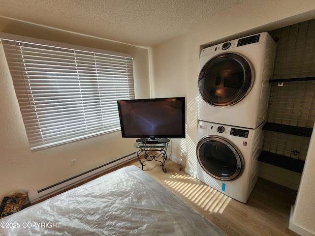 4342 Reka Dr, Anchorage, AK 99508 - laundry room with stacked washing machine and dryer, wood finished floors, a baseboard radiator, and a textured ceiling