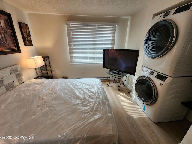 4342 Reka Dr, Anchorage, AK 99508 - bedroom featuring stacked washer / drying machine, wood finished floors, and a textured ceiling