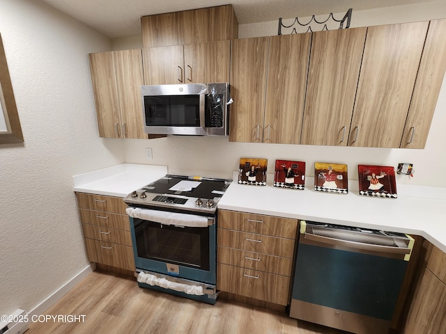 4342 Reka Dr, Anchorage, AK 99508 - kitchen with stainless steel appliances, light wood-style floors, brown cabinets, light countertops, and a textured wall