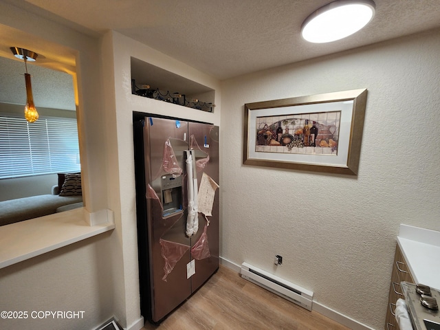 4342 Reka Dr, Anchorage, AK 99508 - laundry room featuring a baseboard heating unit, light wood-style flooring, washing machine and dryer, a textured ceiling, and a textured wall