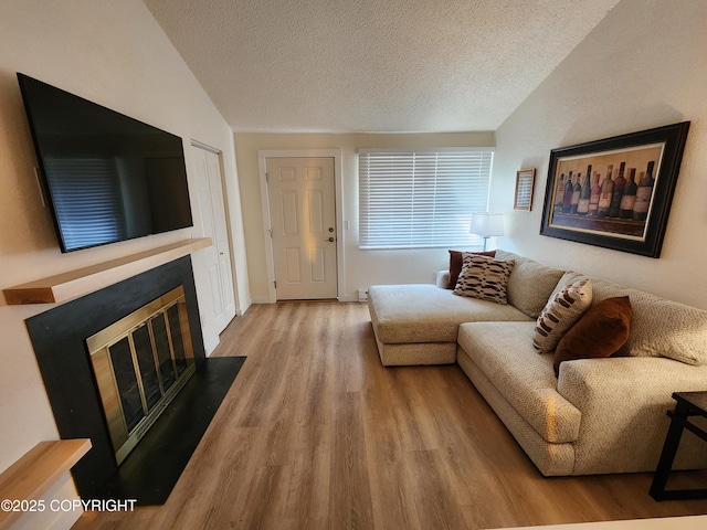 4342 Reka Dr, Anchorage, AK 99508 - living area featuring a textured ceiling, wood finished floors, lofted ceiling, and a fireplace with flush hearth