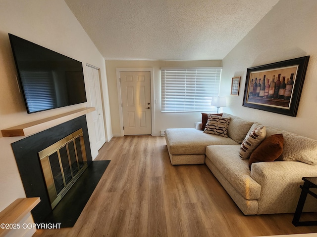 4342 Reka Dr, Anchorage, AK 99508 - living room featuring wood finished floors, a textured ceiling, lofted ceiling, and a fireplace with flush hearth