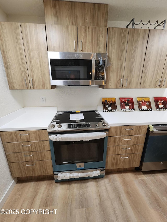 4342 Reka Dr, Anchorage, AK 99508 - kitchen with appliances with stainless steel finishes, light wood-style floors, light countertops, and modern cabinets