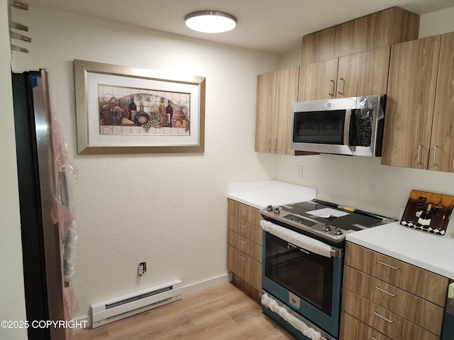 4342 Reka Dr, Anchorage, AK 99508 - kitchen with stainless steel appliances, a baseboard heating unit, light wood finished floors, and light countertops