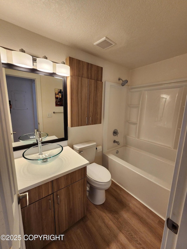 4342 Reka Dr, Anchorage, AK 99508 - bathroom featuring wood finished floors, a textured ceiling, vanity, and bathtub / shower combination