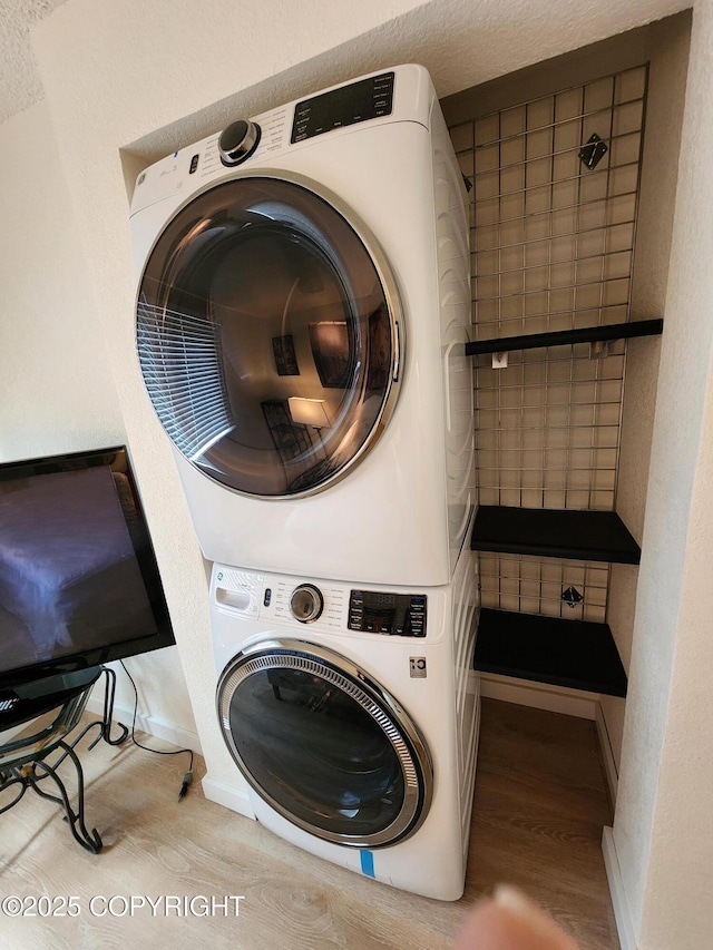 4342 Reka Dr, Anchorage, AK 99508 - laundry room featuring stacked washing machine and dryer and wood finished floors