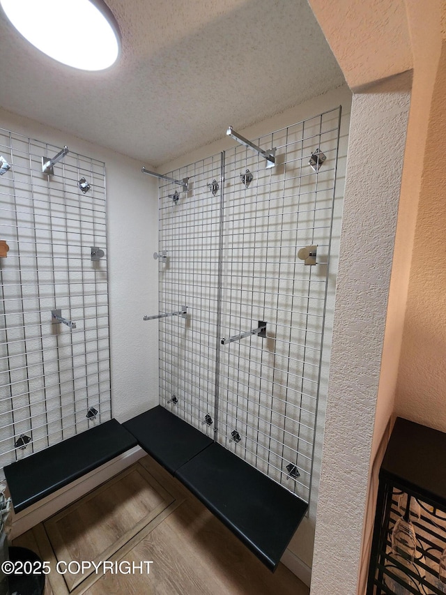 4342 Reka Dr, Anchorage, AK 99508 - full bathroom featuring a shower stall, a textured ceiling, and wood finished floors