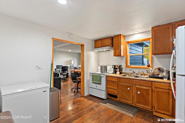 kitchen featuring a textured ceiling, white appliances, sink, and dark wood-type flooring