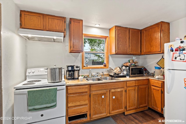 kitchen featuring dark wood-type flooring, sink, and white appliances