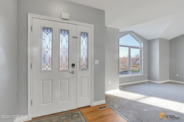 foyer with lofted ceiling and light hardwood / wood-style floors