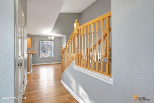 corridor with a notable chandelier and light hardwood / wood-style floors