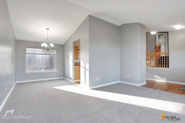 unfurnished living room featuring carpet, lofted ceiling, and a chandelier