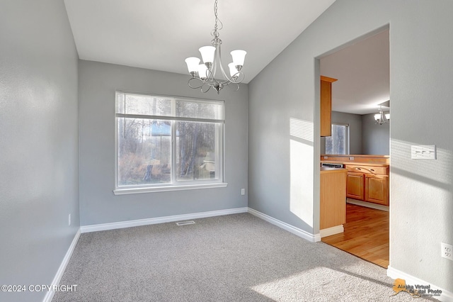 unfurnished dining area featuring light carpet, vaulted ceiling, and a chandelier