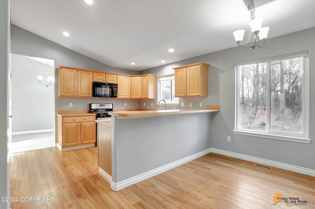 kitchen featuring light brown cabinetry, stainless steel range, a notable chandelier, and kitchen peninsula