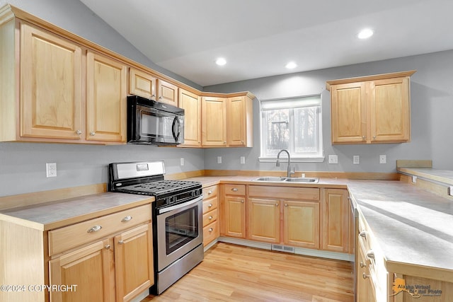 kitchen featuring light brown cabinets, vaulted ceiling, gas range, light hardwood / wood-style floors, and sink