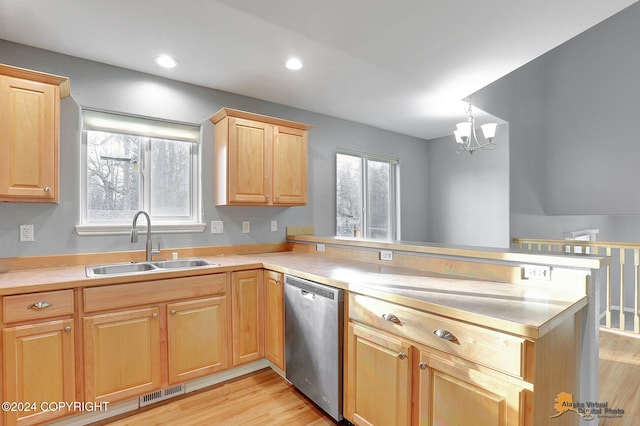 kitchen featuring plenty of natural light, stainless steel dishwasher, sink, and kitchen peninsula